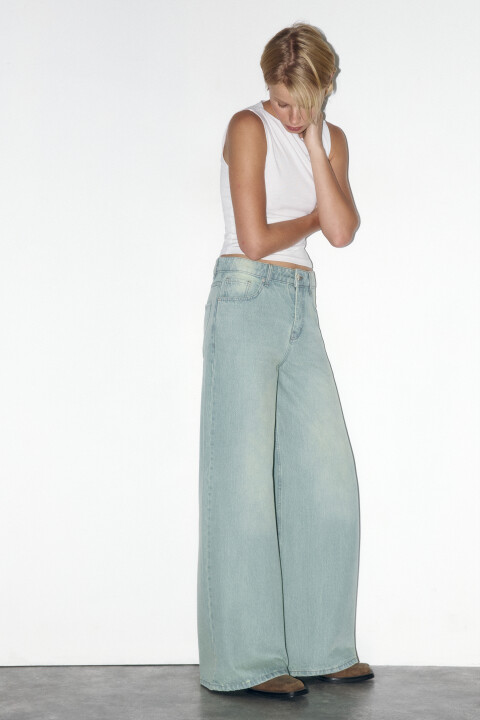 - Широкие женские джинсы-трубы wide leg из мягкого, плотного 100% хлопкового денима  - Классическая средняя посадка подчеркивает фигуру и акцентирует внимание на талии. Длинные прямые штанины, свободные от бедер, без разрезов и декоративных элементов. Два боковых кармана с отрезным бочком, кармашек для мелочи, два накладных кармана сзади. Шлевки для ремня, застежка на молнию и пуговицу спереди. Металлические заклепки на карманах спереди - Синие широкие джинсы с классическим вареным эффектом. Стильные и удобные широкие джинсы-трубы на все времена для расслабленных повседневных, уличных и офисных луков. Сочетай эти базовые джинсы с верхом в разных стилях. С классическим верхом ты сможешь носить эти джинсы в школу, университет или офис. С расслабленным оверсайз-верхом ты получишь удобные кэжуал-аутфиты. В сочетании с топами и корсетами можно создать соблазнительные аутфиты на свидания или вечеринки - Размер на модели: S - Параметры модели: рост 175, бюст 85, талия 64, бедра 93 - Дополни лук поло 2431526015 или лонгсливом BF2441122004