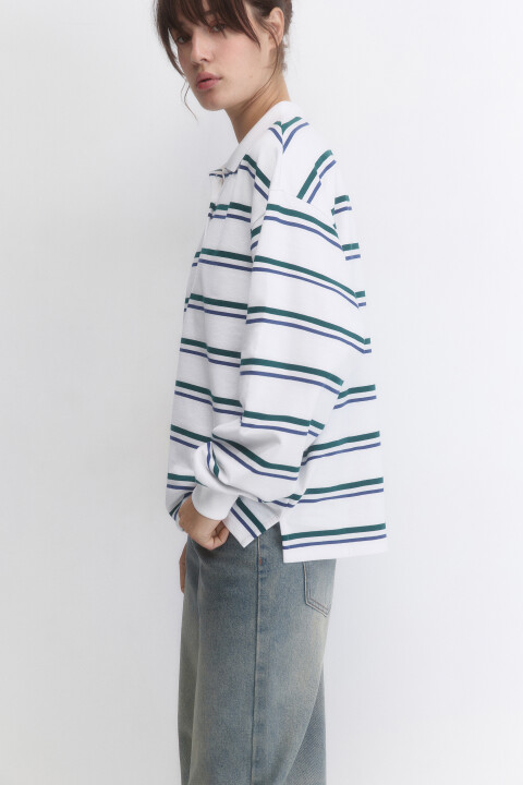 - Короткий женский лонгслив-поло свободного кроя oversize из легкой, дышащей 100% хлопковой ткани с гладкой трикотажной фактурой - Круглый вырез горловины с отложным воротником-поло и застежкой на пуговицы на груди. Длинные свободные рукава с эластичными манжетами. Прямой нижний край без разрезов и декоративных элементов - Лонгслив с принтом из новой осенней коллекции разбавит твои повседневные образы. Легкий дышащий джемпер-поло из хлопка с пуговицами на груди идеально подойдет для расслабленных повседневных аутфитов в трендовом стиле преппи в школу, университет, офис или просто на каждый день. Практичный хлопковый лонгслив-поло с принтом или в полоску - стильное дополнение к широким джинсам или трендовым юбкам-парашютам: выбирай собственный стиль под любое настроение. Заверши образ удобной обувью и аксессуарами из новой коллекции Befree - Размер на модели: S - Параметры модели: рост 177, бюст 80, талия 60, бедра 91 - Дополни лук брюками 2431308015 или джинсами 2431209170