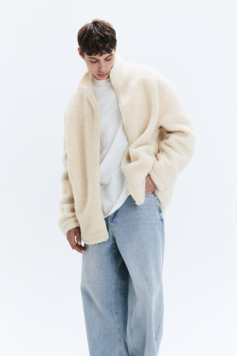 - Короткая мужская куртка-чебурашка свободного кроя oversize из мягкого, пушистого и очень приятного на ощупь искусственного меха под овчину с подкладкой и утеплителем - Высокий воротник-стойка для защиты от ветра. Длинные свободные рукава с прямыми манжетами. Два прорезных боковых кармана без застежки. Застежка на молнию по всей длине спереди. Однотонная ванильно-белая флисовая куртка с меховой фактурой - Объемная плюшевая куртка на демисезон, с которой не захочется расставаться: сочетай ее с удобным низом и создавай стильные расслабленные кэжуал-аутфиты в школу, университет, офис или просто на каждый день. Короткий демисезонный бомбер с утеплением (120 г/м2) идеально подойдет на раннюю осень и позднюю весну до 0 градусов в зависимости от погодных условий региона - Размер на модели: L - Параметры модели: рост 185, грудь 92, талия 76, бедра 91 - Дополни лук джинсами 2413109001