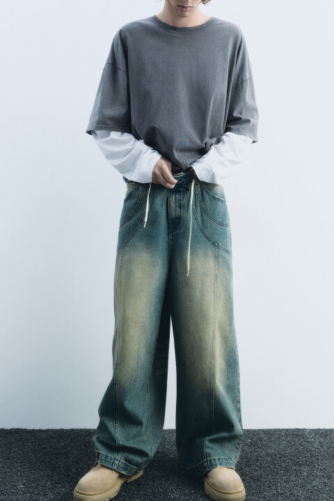 - Широкие мужские джинсы wide leg из плотного хлопкового денима  - Классическая средняя посадка по талии. Застежка на молнию и пуговицу спереди, шлевки для ремня. Два боковых кармана с отрезным бочком, два задних накладных кармана, маленький кармашек для мелочи. Металлические заклепки на карманах спереди, рванина на карманах сзади, декоративные объемные швы - Стильные джинсы с трендовым состаренным эффектом и 